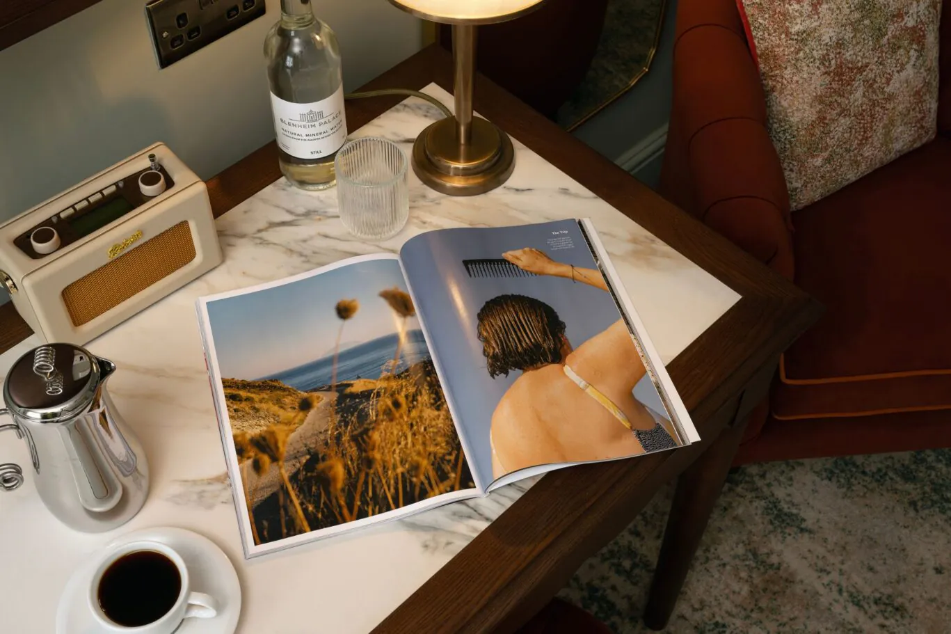 open magazine on table with coffee and radio