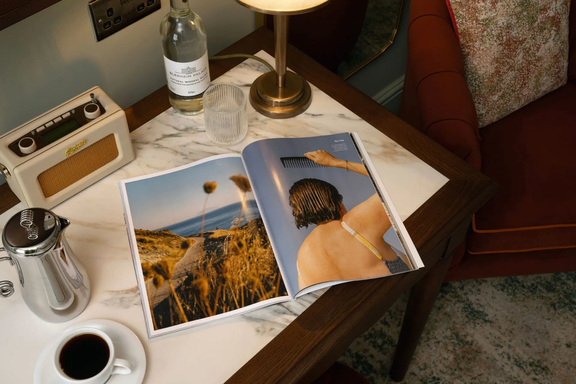 open magazine on table with coffee and radio