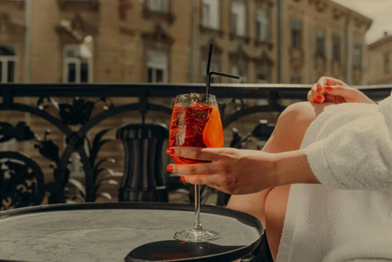 Sutton Summer campaign. Woman drinking cocktail on terrace