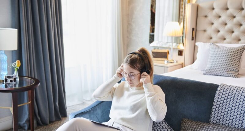 Lady listening to music on hotel sofa