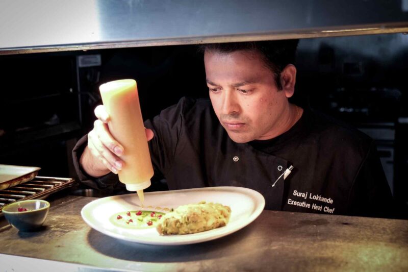 Head-chef-putting-finishing-touches-to-dish-compressed