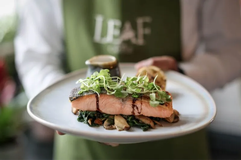 The Castle Hotel Windsor waiter serving seared Scottish salmon