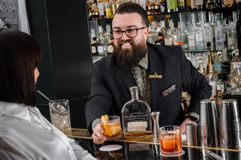 The Athenaeum Hotel & Residences barman and guest making a cocktail